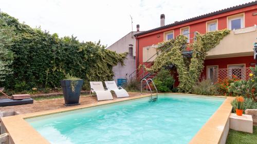 a swimming pool with two chairs and a house at Spapparra B&B in Càbras