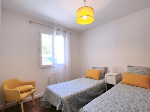 une chambre avec deux lits et une chaise et une fenêtre dans l'établissement Les Yuccas -Maison neuve avec un jardin à Saint Paul de Vence, à Saint-Paul-de-Vence