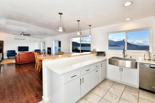 a kitchen with white cabinets and a sink and a table at Bass Alley Bungalow Experience Wc Lodging in Lower Lake