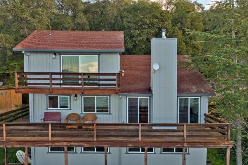 a house on the water with a large deck at Bass Alley Bungalow Experience Wc Lodging in Lower Lake