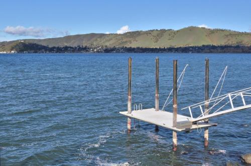 a dock in the middle of a large body of water at Bass Alley Bungalow Experience Wc Lodging in Lower Lake