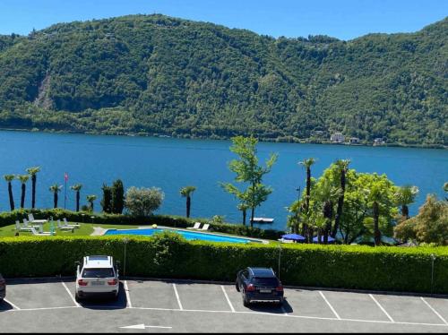 a parking lot with a view of a lake at Holiday On The Lake Lugano 5 in Bissone