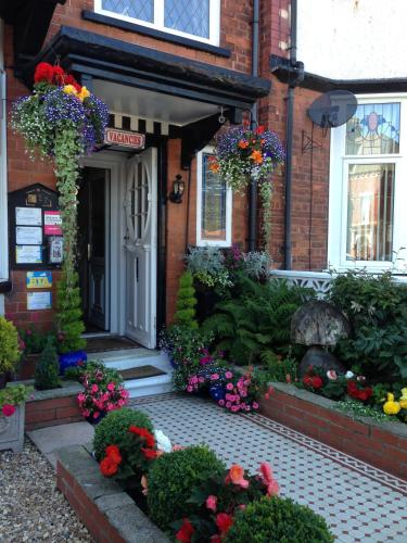 a building with a bunch of flowers in front of it at The Belmont in Bridlington