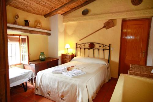 a bedroom with a bed and a chair in a room at vivienda turistica Fuente Zagrilla II in Zagrilla