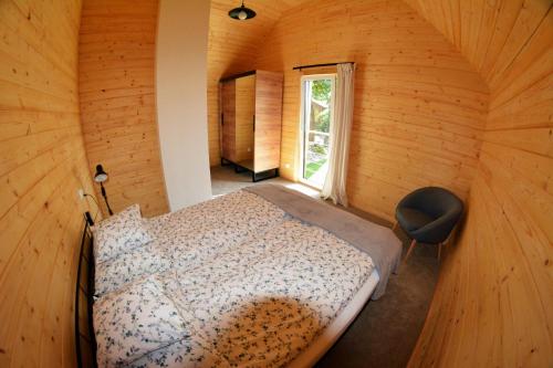 1 dormitorio con 1 cama en una habitación de madera en "Cztery Klony", en Kowale Oleckie