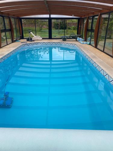 a swimming pool in a house with blue water at Chambre privatif spa in Lestrem