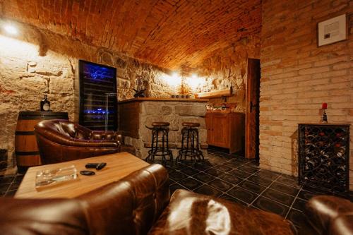 un bar con sillas de cuero, mesa y chimenea en Věž Jičín - Romantika pro 2, en Jičín