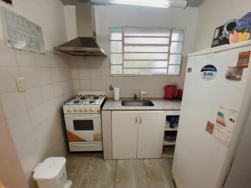a kitchen with a stove and a sink and a refrigerator at Garden Loft in Rosario