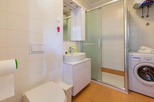 ein Badezimmer mit einem Waschbecken und einer Waschmaschine in der Unterkunft MB APARTMANI in Crikvenica