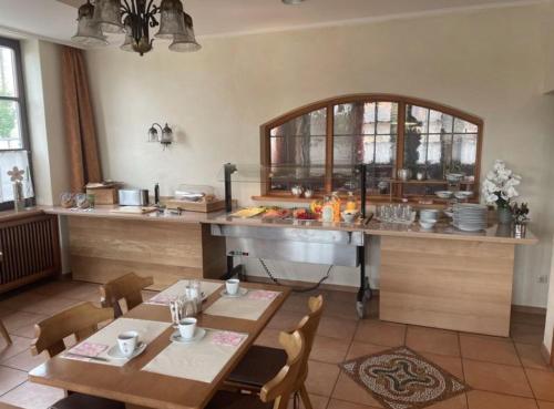 cocina con mesa, sillas y barra en Pension Klosterhof, en Ebelsbach