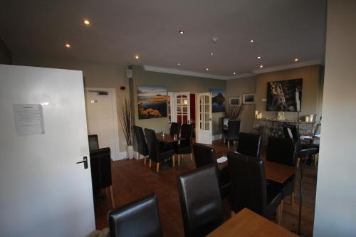 a dining room with black chairs and a table at The Sunningdale in Bamburgh