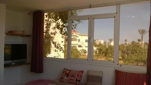 a living room with a large window and a couch at Ranch Tanit Djerba in Midoun