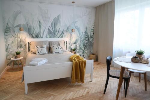 a bedroom with a white bed and a table at Złota#208 in Złota