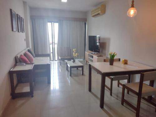 a living room with a couch and a table and a tv at Excelente Flat no Centro de Manaus próximo ao Teatro Amazonas. in Manaus