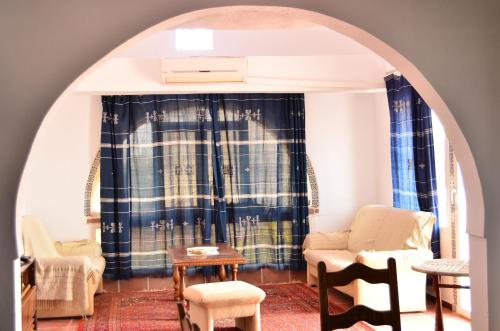 a room with an archway with chairs and a table at Ranch Tanit Djerba in Midoun