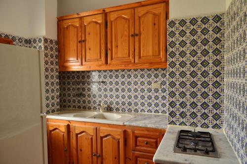 a kitchen with wooden cabinets and a sink at Ranch Tanit Djerba in Midoun