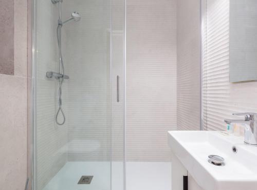 a white bathroom with a shower and a sink at Guadiana · Apartment 2x1, near Sants station in Barcelona