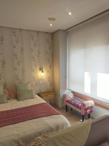 - une chambre avec un lit, un banc et une fenêtre dans l'établissement Centro Loft 2.0, à Oviedo