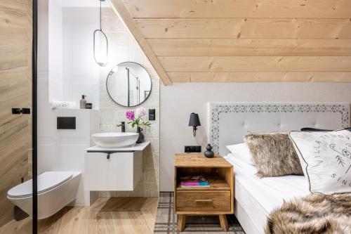 uma casa de banho com uma cama, um lavatório e um espelho. em VILLA TEDDY BEAR Zakopane em Zakopane
