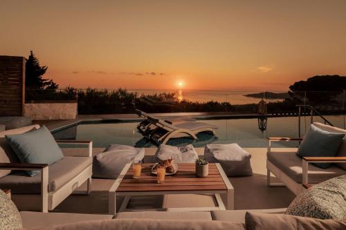 a patio with a table and chairs and a pool at Artemis Villas - Spectacular Views & Ideal For Large Groups, By ZanteWize in Khartáta