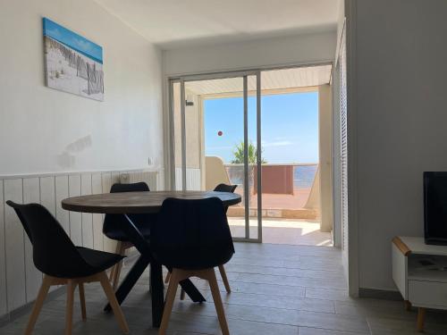 - une salle à manger avec une table et des chaises et une vue sur l'océan dans l'établissement T2 Face à la mer, à Canet