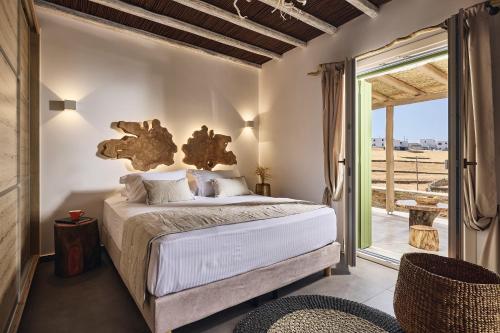 a bedroom with a bed with a large window at Kozadinos Art Suites in Kithnos