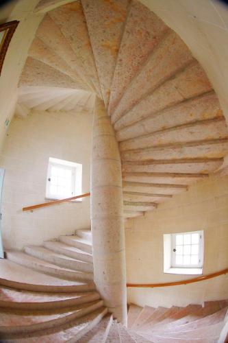 - un escalier en colimaçon dans un bâtiment avec deux fenêtres dans l'établissement Château de la Berchère, à Nuits-Saint-Georges