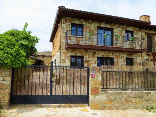 a house with a wooden gate and a fence at Casa Rural El Remolón in Piñuécar