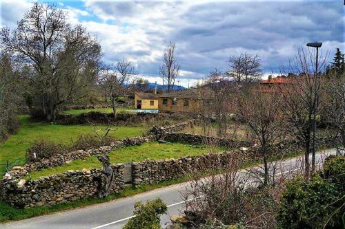 a road with a stone wall next to a house at Casa Rural El Remolón in Piñuécar