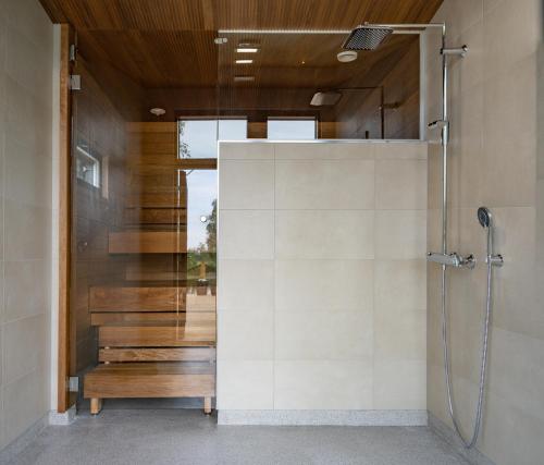 La salle de bains est pourvue d'une douche avec une porte en verre. dans l'établissement Villa Suisto, à Pori