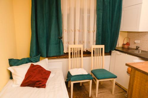 a small room with a bed and two chairs at Pensiunea Anda - Savarsin in Savarsin