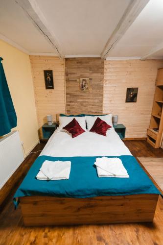 a bedroom with a large bed with red and white pillows at Pensiunea Anda - Savarsin in Savarsin