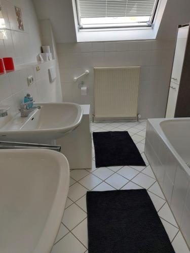 La salle de bains est pourvue d'un lavabo, d'une baignoire et de toilettes. dans l'établissement Ferienwohnung Frankfurt, à Neu-Anspach