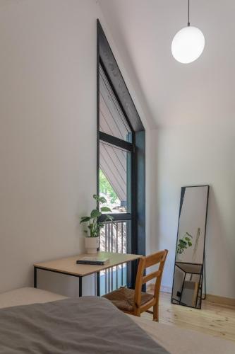 a bedroom with a table and a chair and a window at Czarny domek w górach in Pieszyce