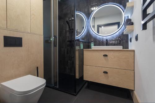 a bathroom with a toilet and a sink and a mirror at Czarny domek w górach in Pieszyce