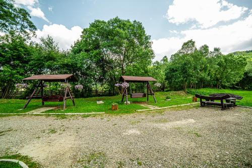 a park with two picnic tables and a bench at Pensiunea ARC Bucovina in Vama