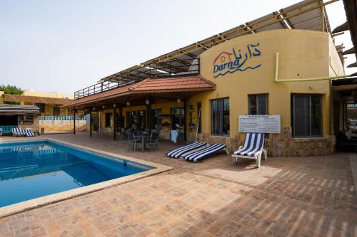a patio area with a pool, chairs, and tables at Darna Divers Village in Aqaba