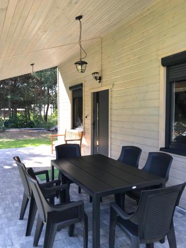 a black table and chairs on a patio at Leśny Domek in Czerwona Wola