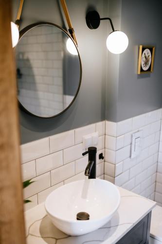 a white sink in a bathroom with a mirror at Piękne Pole in Łaziska