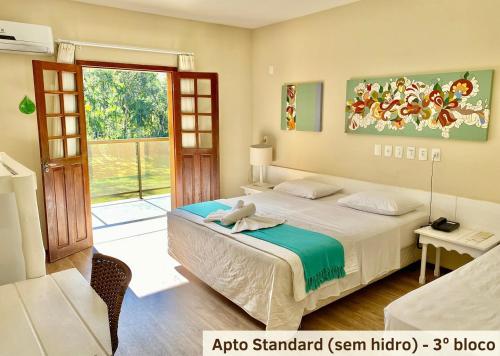 a bedroom with a bed and a sliding glass door at Hotel Fazenda Vale das Pedras in Jaraguá do Sul