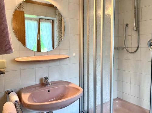 a bathroom with a sink and a shower and a mirror at Haus Jagerer in Ramsau