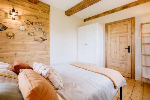 a bedroom with a bed and a wooden wall at Piękne Pole in Łaziska