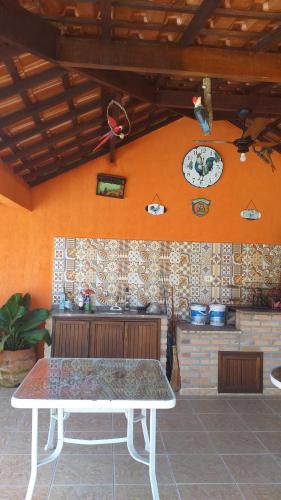 a table in front of a kitchen with a plate on the wall at Rancho do Colega in Santa Branca