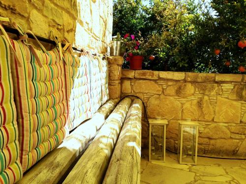 a wooden bench sitting next to a stone wall at Lofou Traditional Stone House in Lofou