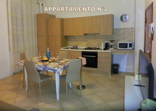 a kitchen with a table and chairs in a kitchen at Red & Blu Apartments in Desenzano del Garda