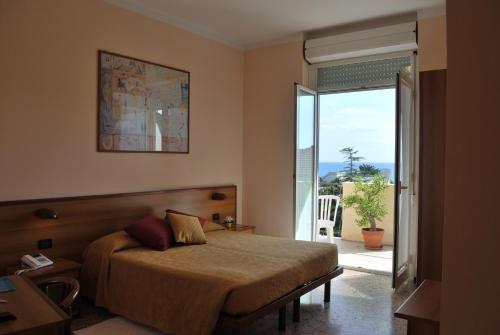 1 dormitorio con 1 cama y puerta corredera de cristal en Hotel Galleano, en Andora