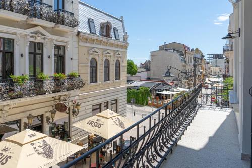 a balcony with tables and umbrellas on a city street at Olympic Boutique in Constanţa