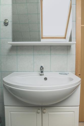 a bathroom with a white sink and a mirror at Apartment Amak with free onsite parking in Bovec