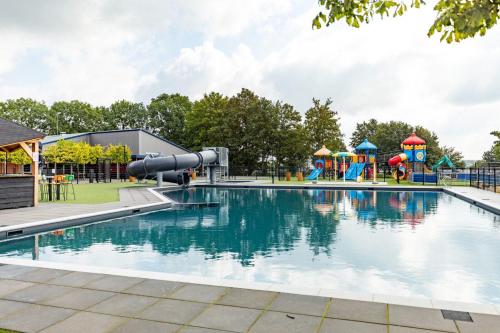 a swimming pool with a playground and a slide at Rhederlaagse Meren in Lathum