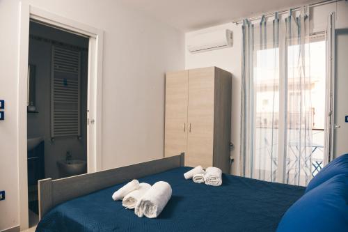 sypialnia z niebieskim łóżkiem i ręcznikami na nim w obiekcie Corso Italia Rooms by AP Apartment w mieście Gallipoli